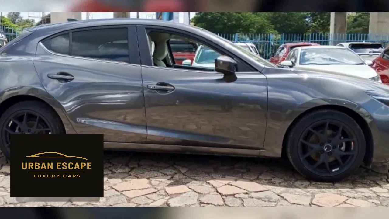 Mazda Axela hatchback in grey, side view with black alloy wheels