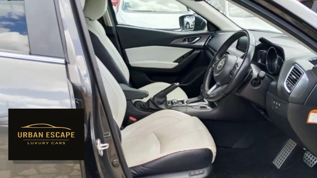 Mazda Axela front seats in cream with black trim, seen through the open driver's door