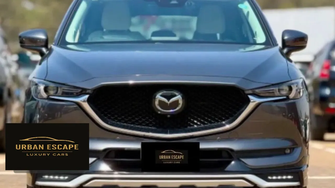 Mazda CX-5 in dark grey, head-on front view of the grille, badge and headlights
