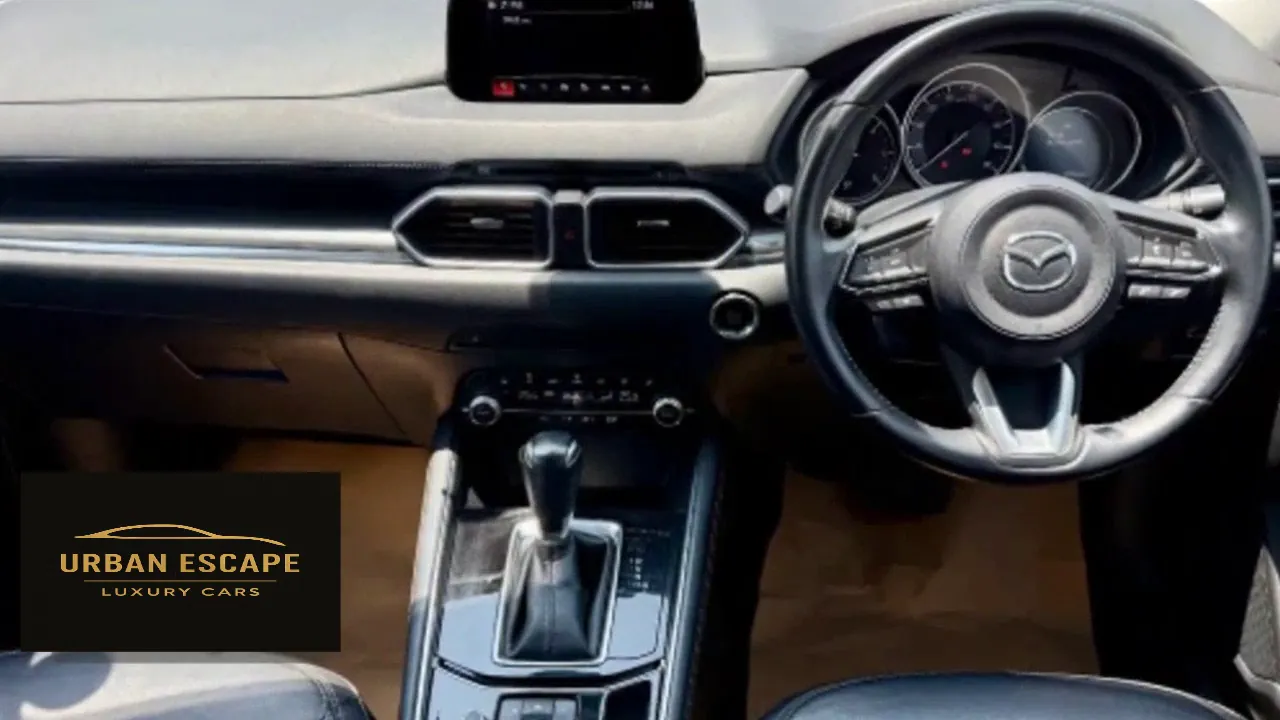 Mazda CX-5 dashboard with steering wheel on the right, dials, top screen and automatic gear selector