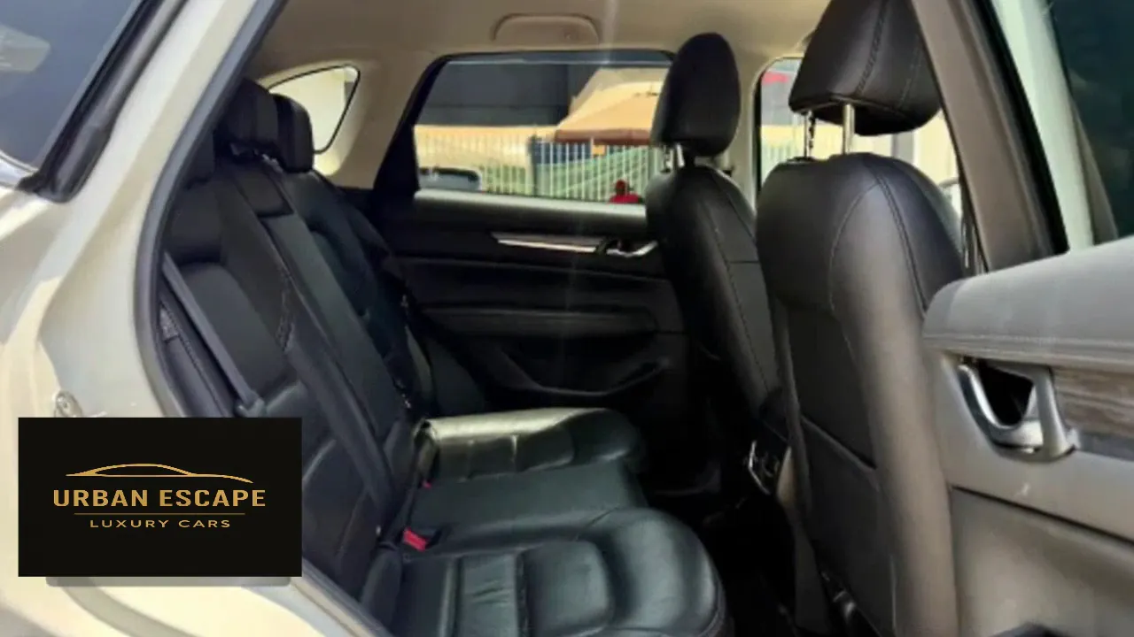 Mazda CX-5 in white, black leather back seats seen through the open rear door