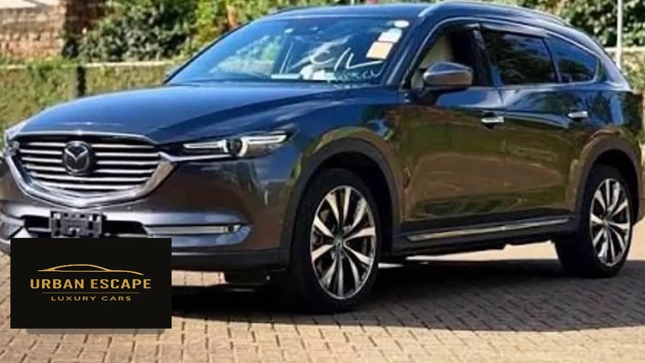 Mazda CX-8 in dark blue, front three-quarter view with chrome grille and alloy wheels