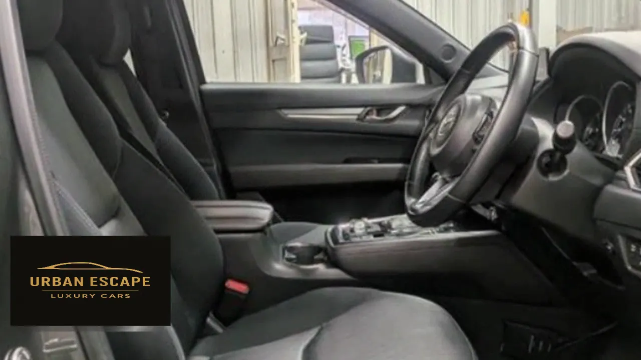 Mazda CX-8 front seats in black fabric, seen through the driver's door with the steering wheel