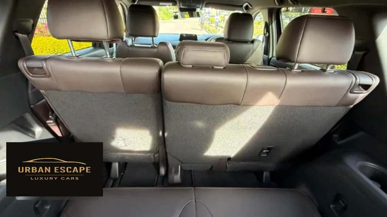 Mazda CX-8 cabin from the back, with three rows of brown leather seats and carpeted second-row seat backs