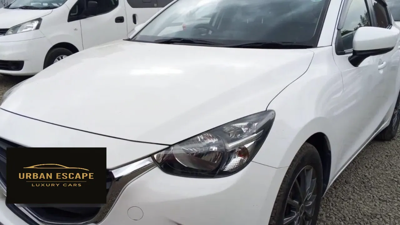 Mazda Demio in white, front three-quarter view from the left showing bonnet, headlight and windscreen