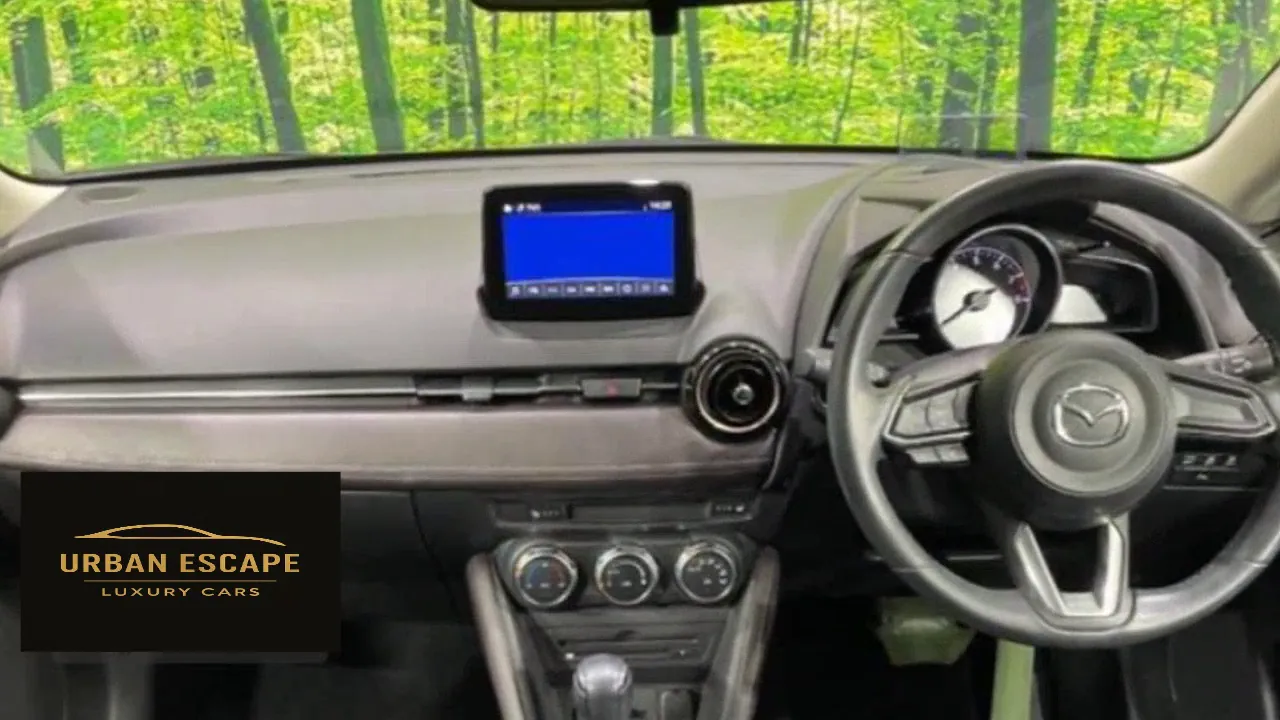 Mazda Demio right-hand-drive dashboard with centre screen, steering wheel buttons and three climate dials