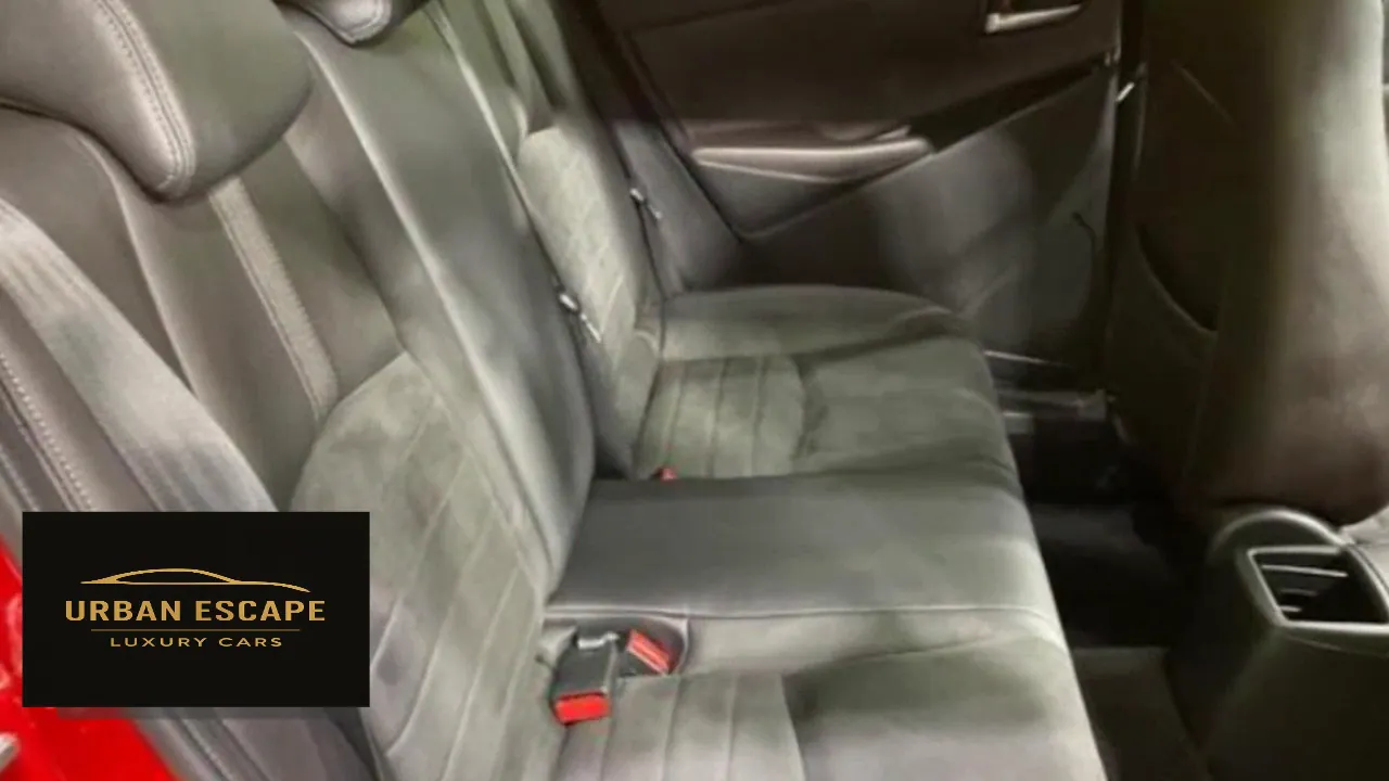 Mazda Demio in red, dark grey back seats with suede-look inserts and red-tipped seat belt buckles