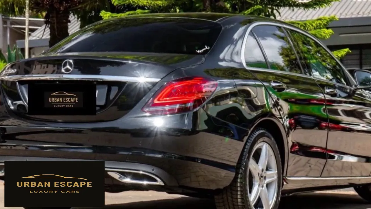 Mercedes-Benz C 200 in black, rear three-quarter view with red tail light and chrome exhaust trim