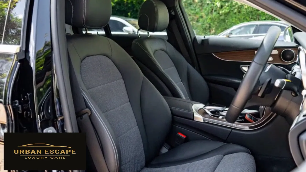 Mercedes-Benz C 200 black front seats with grey fabric inserts, seen through the open driver's door