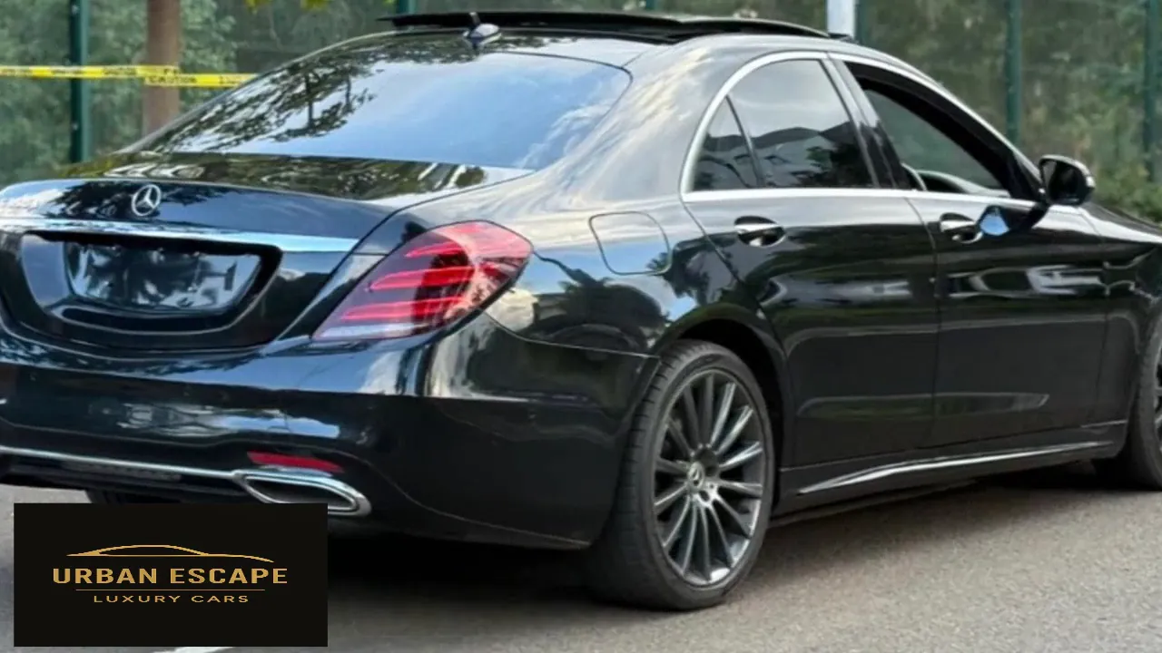 Mercedes-Benz S 350 in black, rear three-quarter view with sunroof open, red tail light and chrome exhaust trim