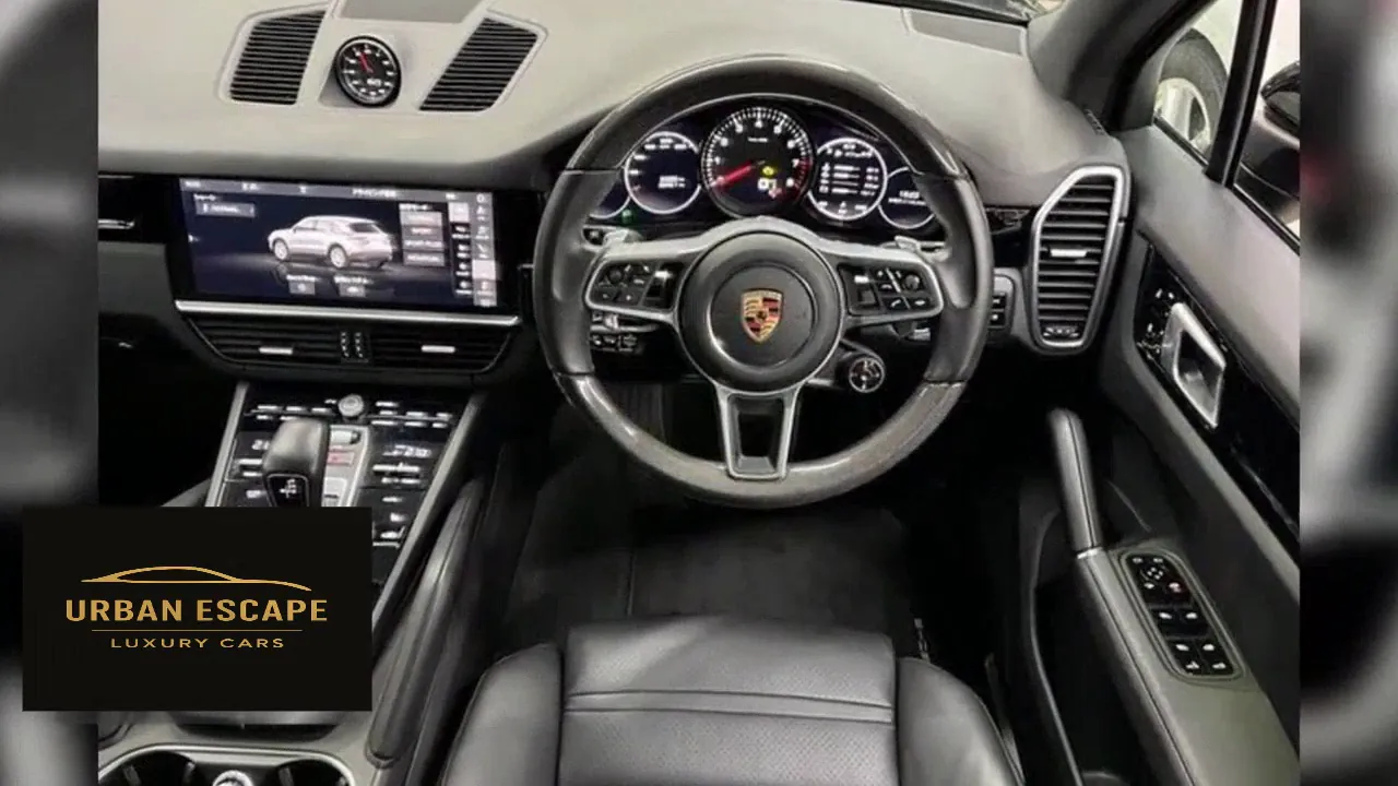 Porsche Cayenne black leather interior with dashboard touch screen, instrument dials and steering wheel