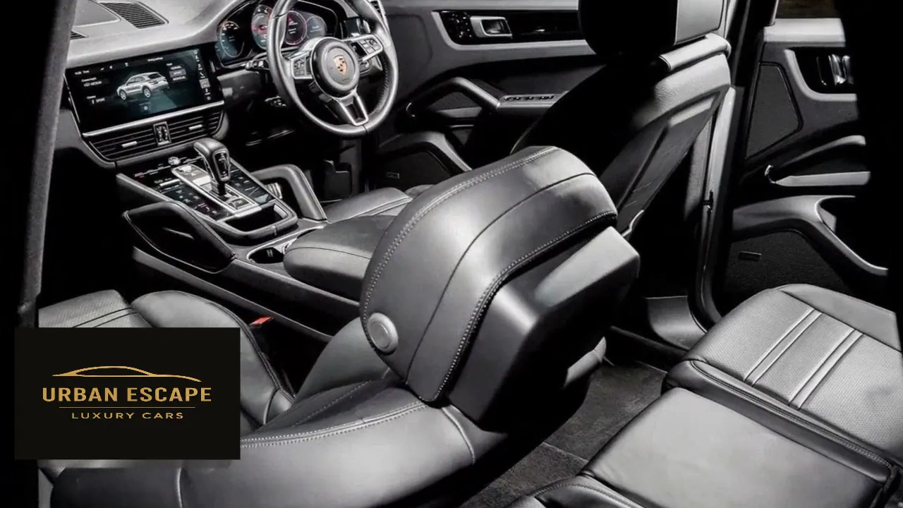 Porsche Cayenne black leather cabin seen from behind, with front seat, centre console and touch screen