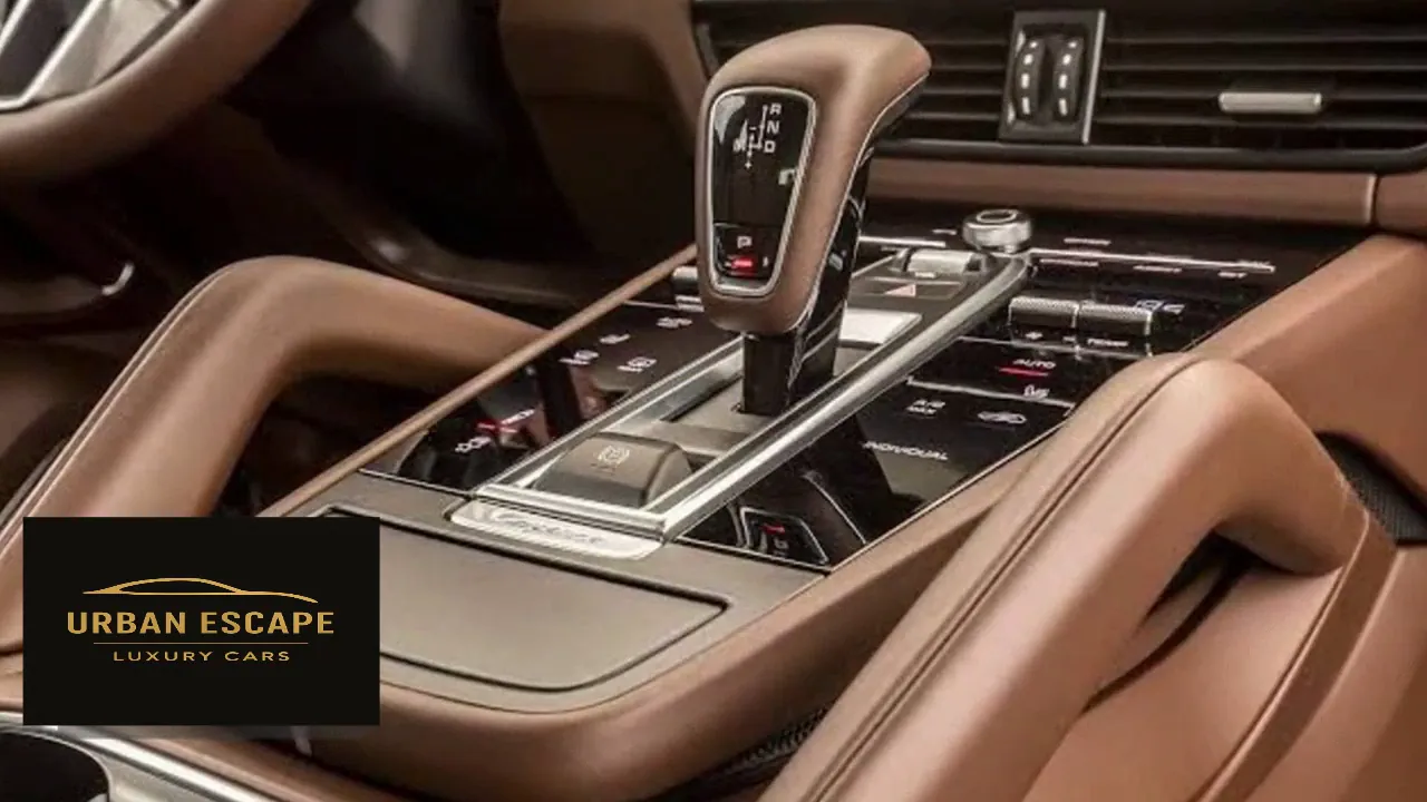 Porsche Cayenne gear selector and glossy black centre console controls, trimmed in brown leather
