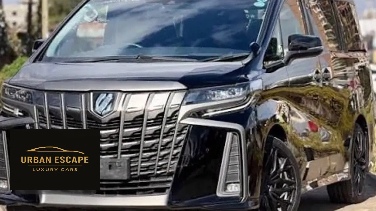 Toyota Alphard in black, front three-quarter view with large chrome grille and black alloy wheels
