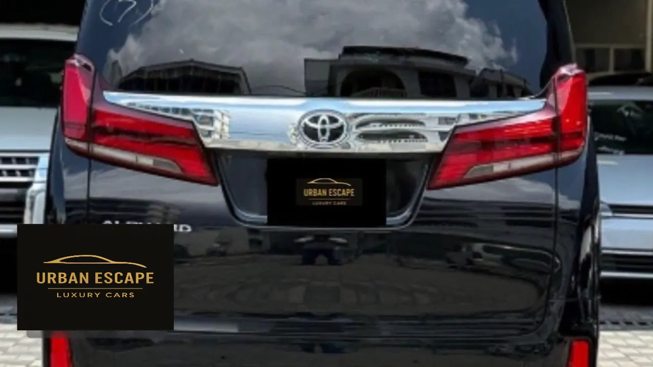 Toyota Alphard in black, rear view with chrome tailgate trim, Toyota badge and red tail lights