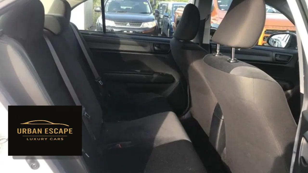 Toyota Axio back seats in dark grey fabric, seen through the open rear door
