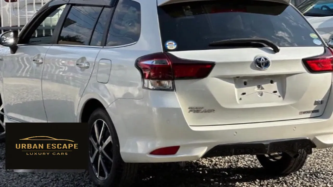 Toyota Corolla Fielder in white, rear three-quarter view showing tailgate, tail lights and alloy wheel