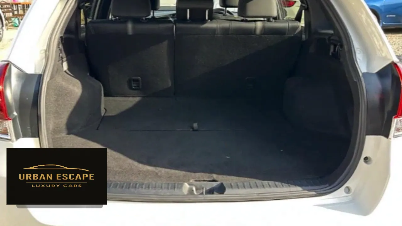 Toyota Corolla Fielder in white, open boot with carpeted floor and split rear seat backs