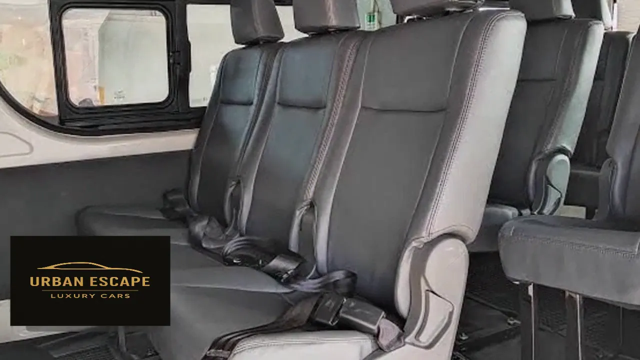 Toyota Hiace passenger cabin with rows of charcoal leather seats, headrests and seat belts