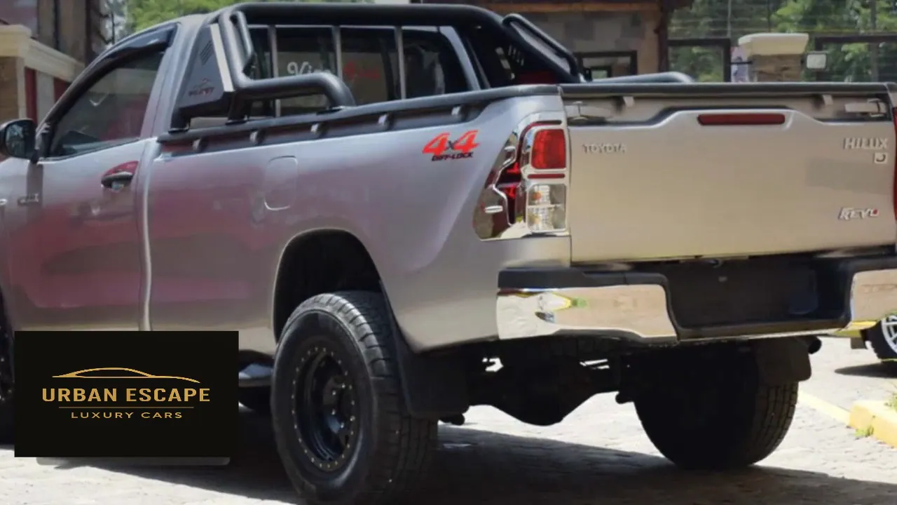 Toyota Hilux Single Cab in silver, rear three-quarter view with roll bar, 4x4 decal and black wheels