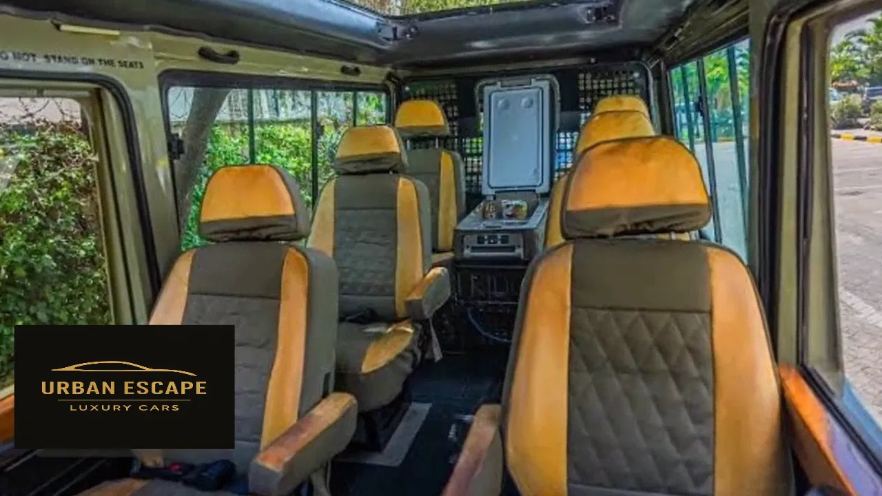 Toyota Land Cruiser Safari cabin with orange and grey quilted seats in rows and a fridge at the back