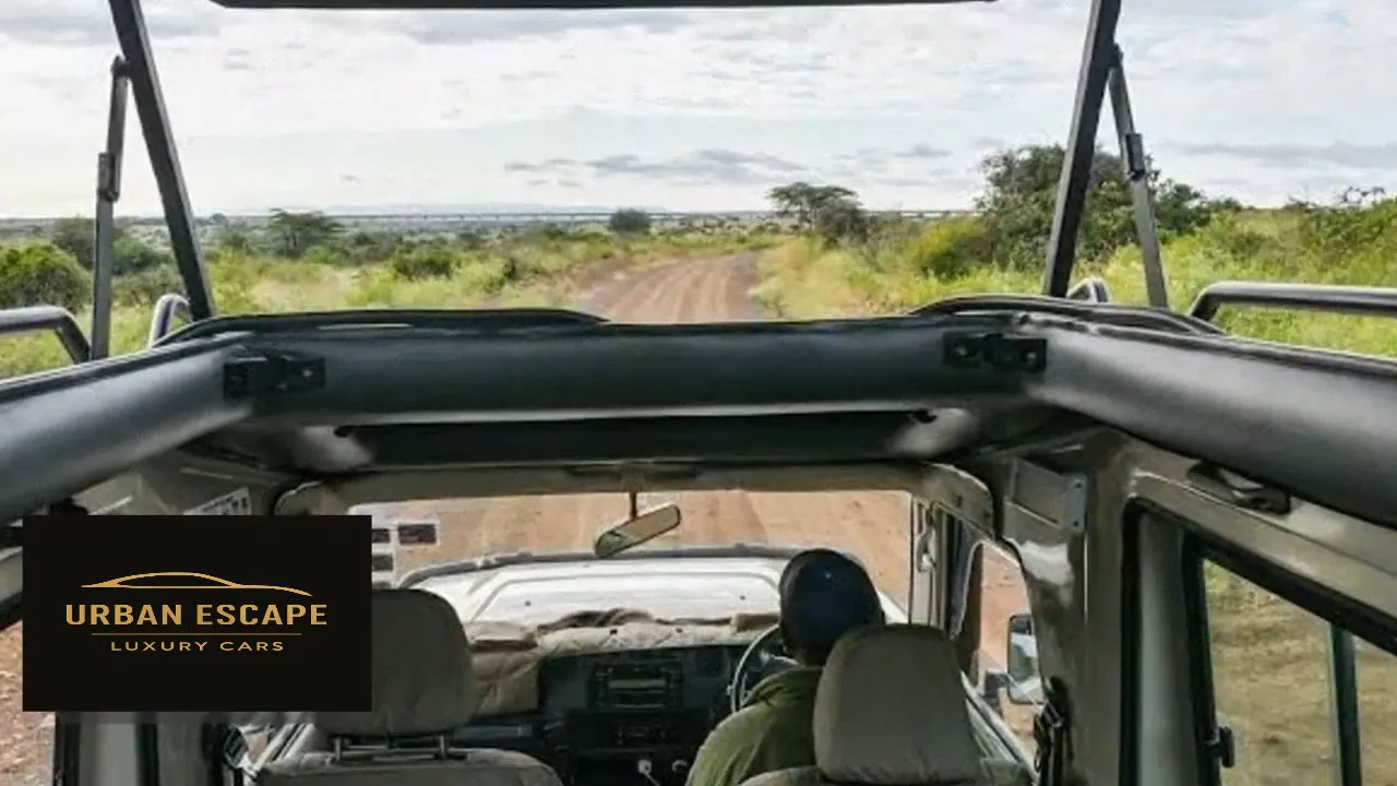 Toyota Land Cruiser Safari with pop-up roof raised, seen from the back seats towards the driver and a dirt track
