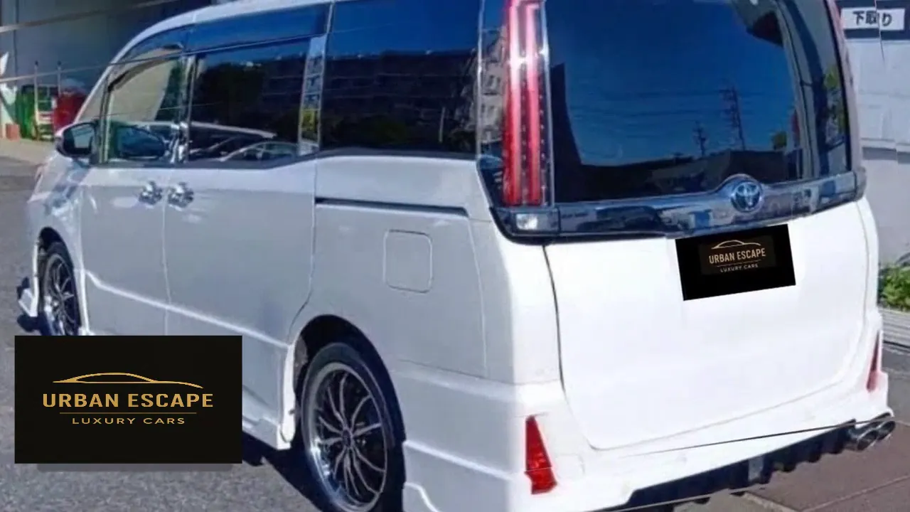 Toyota Noah in white, rear three-quarter view with tall tail light, dark tinted rear window and twin exhaust tips
