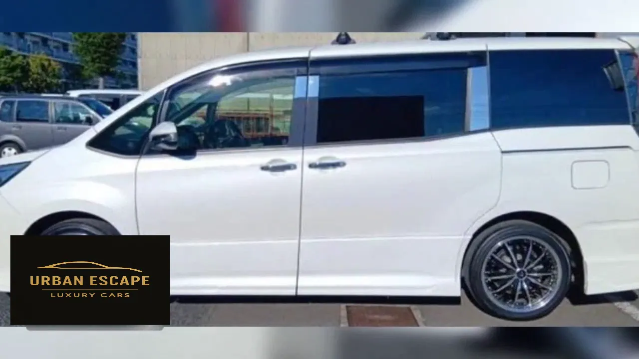 Toyota Noah in white, left side profile with front door, sliding rear door and alloy wheel