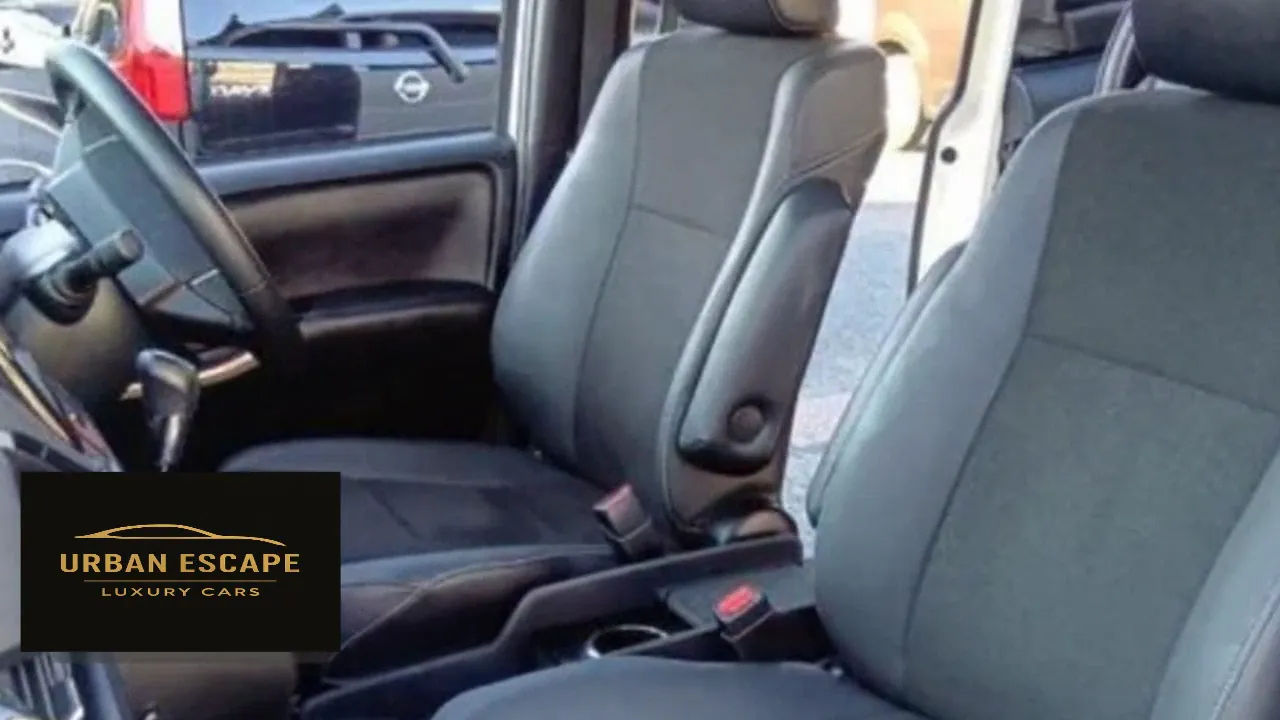 Toyota Noah front seats in dark grey with fabric centres and an armrest, seen from the passenger side