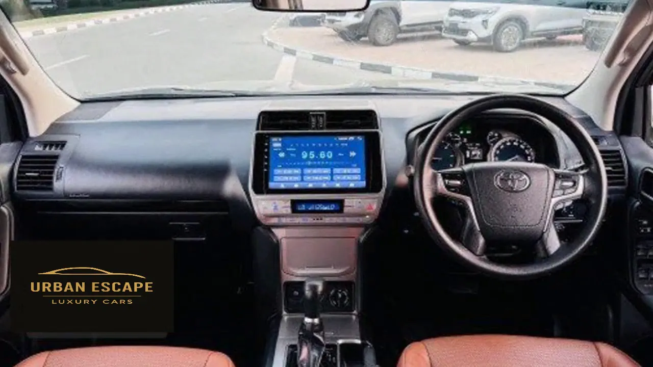 Toyota Land Cruiser Prado dashboard with centre touch screen, steering wheel and tan leather front seats
