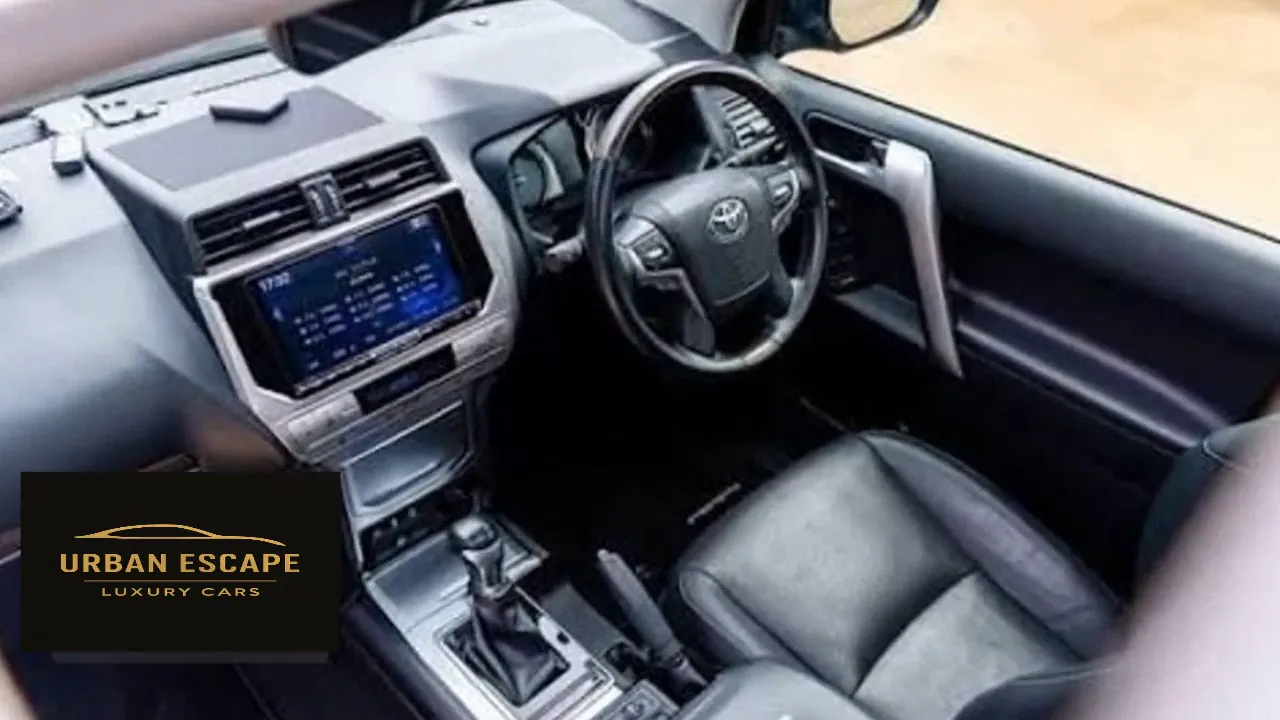 Toyota Land Cruiser Prado interior with black leather driver's seat, steering wheel and centre screen